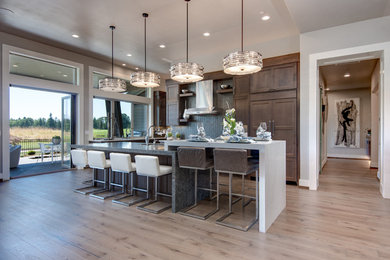 Inspiration for a transitional light wood floor and beige floor kitchen remodel in Portland with shaker cabinets, dark wood cabinets, gray backsplash and paneled appliances