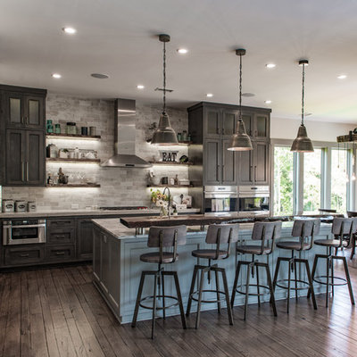 Large mountain style l-shaped brown floor and dark wood floor eat-in kitchen photo in Charleston with shaker cabinets, stainless steel appliances, an island, dark wood cabinets, a farmhouse sink, quartzite countertops, gray backsplash and stone tile backsplash