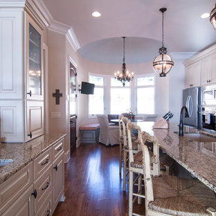Large transitional eat-in kitchen in Charlotte with an undermount sink, raised-panel cabinets, beige cabinets, granite benchtops, beige splashback, matchstick tile splashback, stainless steel appliances, medium hardwood floors and with island.