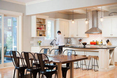 Classic kitchen/diner in Charleston with a belfast sink, white cabinets, white splashback and metro tiled splashback.