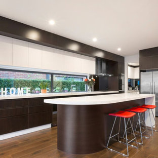 Design ideas for a contemporary kitchen in Melbourne with an undermount sink, flat-panel cabinets, brown cabinets, window splashback, stainless steel appliances, medium hardwood floors, with island, brown floor and white benchtop.