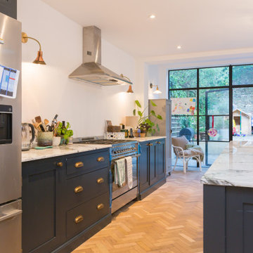 Stunning dark blue open plan kitchen with large island and white quartz worktops