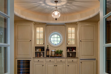 Imagen de cocinas en L clásica de tamaño medio cerrada con electrodomésticos con paneles y suelo de madera en tonos medios