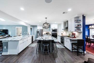 Example of a large transitional u-shaped dark wood floor and brown floor kitchen design in DC Metro with an undermount sink, shaker cabinets, white cabinets, quartzite countertops, gray backsplash, subway tile backsplash, stainless steel appliances, two islands and multicolored countertops