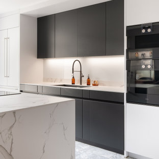 Immagine di una cucina moderna di medie dimensioni con ante lisce, top in superficie solida, elettrodomestici neri, pavimento in marmo, top bianco, lavello sottopiano, ante nere e pavimento grigio