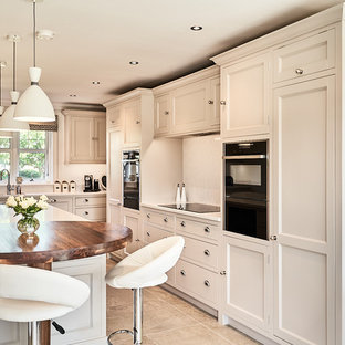 Design ideas for a medium sized traditional kitchen in Other with recessed-panel cabinets, white cabinets, quartz worktops, an island, white worktops, white splashback, mosaic tiled splashback, black appliances and brown floors.