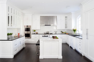 Diseño de cocinas en U tradicional renovado con puertas de armario blancas, salpicadero blanco, suelo de madera oscura y suelo marrón