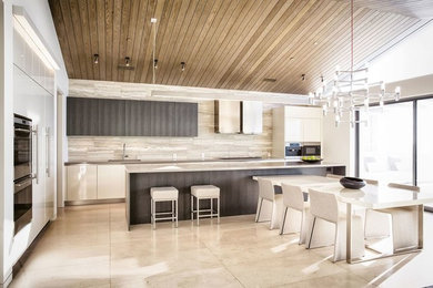 Example of a mid-sized trendy single-wall travertine floor and beige floor open concept kitchen design in Austin with an undermount sink, flat-panel cabinets, dark wood cabinets, stainless steel countertops, beige backsplash, stone tile backsplash, stainless steel appliances and an island