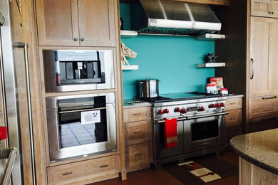 Diseño de cocina comedor contemporánea con encimera de granito, salpicadero azul, electrodomésticos de acero inoxidable y una isla