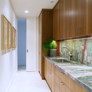 Photo of a large contemporary galley kitchen pantry in Hawaii with flat-panel cabinets, medium wood cabinets, granite benchtops, green splashback, stone slab splashback, travertine floors, with island, an undermount sink and panelled appliances.