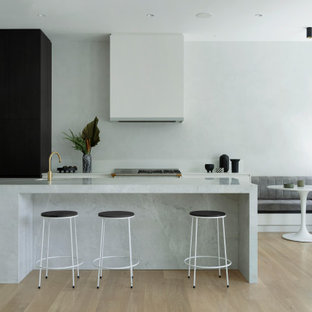 Contemporary galley eat-in kitchen in Perth with flat-panel cabinets, white cabinets, light hardwood floors, with island, beige floor and grey benchtop.