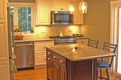 Small transitional l-shaped light wood floor eat-in kitchen photo in Boston with an undermount sink, raised-panel cabinets, white cabinets, quartz countertops, beige backsplash, stone tile backsplash, stainless steel appliances and an island