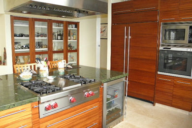 Ejemplo de cocina contemporánea grande con fregadero de un seno, armarios con paneles lisos, puertas de armario de madera oscura, encimera de granito, salpicadero gris, salpicadero de losas de piedra, electrodomésticos de acero inoxidable, suelo de baldosas de porcelana, una isla y suelo beige