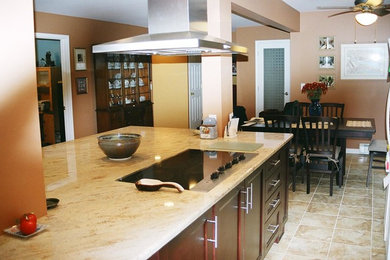 Example of a mid-sized transitional l-shaped porcelain tile and beige floor eat-in kitchen design in New York with shaker cabinets, dark wood cabinets, soapstone countertops, stainless steel appliances and an island