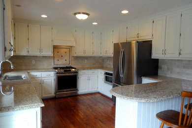 Bild på ett mellanstort vintage kök, med en dubbel diskho, luckor med upphöjd panel, vita skåp, granitbänkskiva, beige stänkskydd, stänkskydd i keramik, rostfria vitvaror, mörkt trägolv och en halv köksö