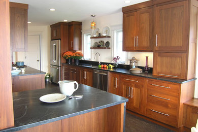Eat-in kitchen - mid-sized contemporary galley brown floor eat-in kitchen idea in Boston with an undermount sink, shaker cabinets, medium tone wood cabinets, soapstone countertops, stainless steel appliances and a peninsula