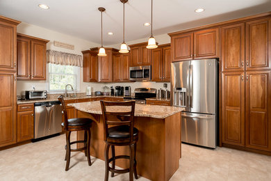 Elegant l-shaped eat-in kitchen photo in DC Metro with raised-panel cabinets and an island