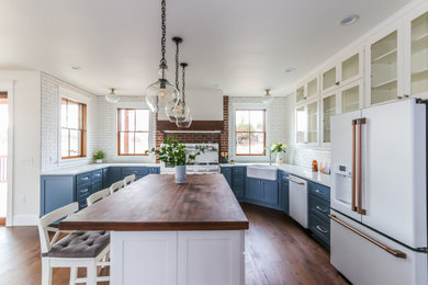Inspiration for a large cottage u-shaped medium tone wood floor and brown floor eat-in kitchen remodel in Seattle with a farmhouse sink, shaker cabinets, blue cabinets, quartz countertops, white backsplash, subway tile backsplash, white appliances, an island and white countertops