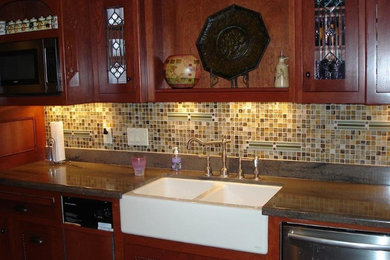 Kitchen - mid-sized transitional kitchen idea in Other with a farmhouse sink, glass-front cabinets, medium tone wood cabinets, brown backsplash, mosaic tile backsplash and stainless steel appliances