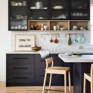 Mittelgroße Mid-Century Wohnküche in L-Form mit Landhausspüle, Schrankfronten im Shaker-Stil, schwarzen Schränken, Marmor-Arbeitsplatte, Küchenrückwand in Grau, Rückwand aus Keramikfliesen, Küchengeräten aus Edelstahl, hellem Holzboden, Kücheninsel, braunem Boden und grauer Arbeitsplatte in Sydney