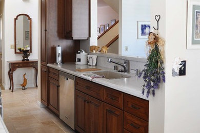 Eat-in kitchen - traditional galley ceramic tile eat-in kitchen idea in Los Angeles with a double-bowl sink, raised-panel cabinets, medium tone wood cabinets, quartz countertops, beige backsplash, stainless steel appliances and no island