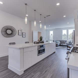 Open concept kitchen ideas - Single-wall open concept kitchen photo in San Francisco with an undermount sink, flat-panel cabinets, white cabinets, stainless steel appliances, an island and white countertops