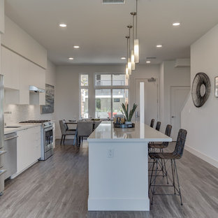 Open concept kitchen pictures - Open concept kitchen - single-wall open concept kitchen idea in San Francisco with an undermount sink, flat-panel cabinets, white cabinets, stainless steel appliances, an island and white countertops