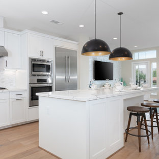 Open concept kitchen ideas - L-shaped open concept kitchen photo in San Francisco with shaker cabinets, white cabinets, stainless steel appliances and an island