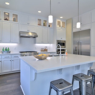 Open concept kitchen inspiration - Inspiration for a l-shaped dark wood floor open concept kitchen remodel in San Francisco with an undermount sink, shaker cabinets, white cabinets, stainless steel appliances and an island