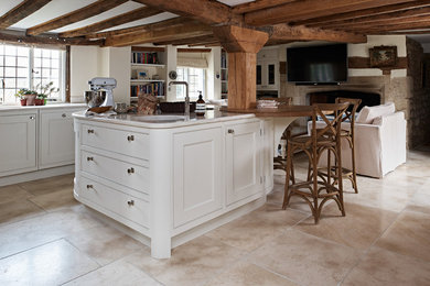 Design ideas for a medium sized traditional kitchen/diner in Oxfordshire with composite countertops, stainless steel appliances, limestone flooring, an island and beige floors.