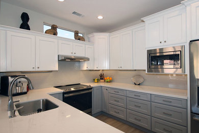 Foto på ett funkis vit kök, med en undermonterad diskho, skåp i shakerstil, grå skåp, bänkskiva i kvartsit, grått stänkskydd, stänkskydd i porslinskakel, rostfria vitvaror, klinkergolv i porslin och beiget golv