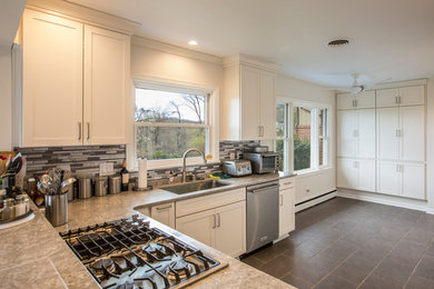 Example of a large transitional single-wall ceramic tile and gray floor eat-in kitchen design in Other with an undermount sink, shaker cabinets, white cabinets, solid surface countertops, gray backsplash, mosaic tile backsplash, stainless steel appliances and no island
