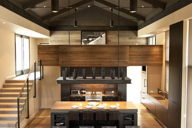 Trendy open concept kitchen photo in Boise with flat-panel cabinets, dark wood cabinets, brown backsplash and glass sheet backsplash