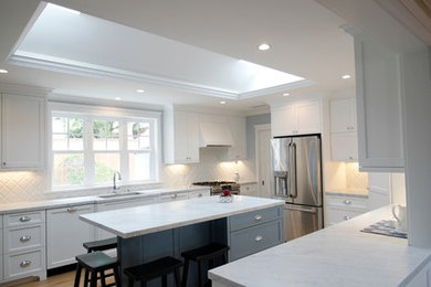 This is an example of a medium sized nautical u-shaped kitchen/diner in Los Angeles with a single-bowl sink, shaker cabinets, white cabinets, marble worktops, white splashback, ceramic splashback, stainless steel appliances, light hardwood flooring, an island, beige floors and white worktops.
