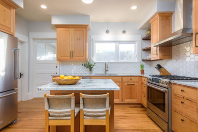 Example of a mid-sized trendy light wood floor eat-in kitchen design in Seattle with an undermount sink, flat-panel cabinets, light wood cabinets, granite countertops, white backsplash, ceramic backsplash, stainless steel appliances and an island