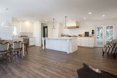 Eat-in kitchen - large country l-shaped medium tone wood floor and brown floor eat-in kitchen idea in San Diego with a farmhouse sink, recessed-panel cabinets, white cabinets, marble countertops, white backsplash, subway tile backsplash, stainless steel appliances and an island
