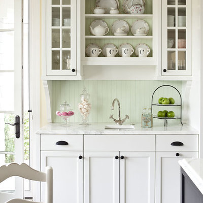 Example of a mid-sized classic kitchen design in Minneapolis with an undermount sink, white cabinets, marble countertops, green backsplash and glass-front cabinets