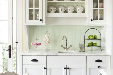 Foto de cocina tradicional de tamaño medio con fregadero bajoencimera, puertas de armario blancas, encimera de mármol, salpicadero gris y armarios tipo vitrina