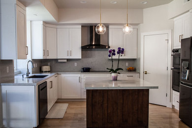 Example of a mid-sized transitional u-shaped light wood floor and beige floor eat-in kitchen design in San Francisco with a drop-in sink, shaker cabinets, white cabinets, quartz countertops, gray backsplash, stone slab backsplash, stainless steel appliances, an island and white countertops