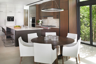 Example of a trendy galley beige floor eat-in kitchen design in Miami with an undermount sink, flat-panel cabinets, medium tone wood cabinets, beige backsplash, an island and beige countertops