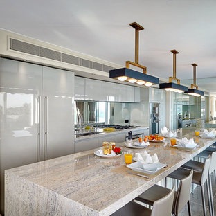 Inspiration pour une grand cuisine américaine linéaire design avec un évier encastré, des portes de placard grises, une crédence en carreau de miroir et un sol en carrelage de céramique.