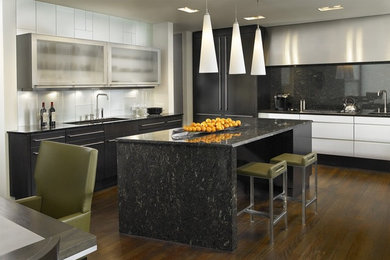 Inspiration for a contemporary l-shaped eat-in kitchen remodel in Chicago with glass-front cabinets, black backsplash, stone slab backsplash, black appliances and black countertops