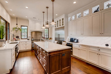 Example of a classic u-shaped laminate floor eat-in kitchen design in Phoenix with a farmhouse sink, recessed-panel cabinets, white cabinets, quartzite countertops, stone slab backsplash, stainless steel appliances and an island