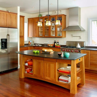 Eat-in kitchen - mid-sized craftsman u-shaped medium tone wood floor and brown floor eat-in kitchen idea in New York with an island, shaker cabinets, medium tone wood cabinets, granite countertops, beige backsplash, terra-cotta backsplash, stainless steel appliances, an undermount sink and black countertops