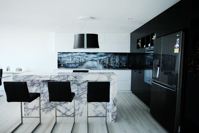 Cette image montre une cuisine minimaliste de taille moyenne avec plan de travail en marbre et îlot.