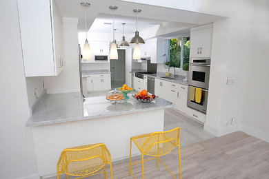Large transitional u-shaped kitchen photo in Miami with an undermount sink, flat-panel cabinets, white cabinets, marble countertops and white backsplash