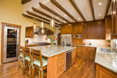 Eat-in kitchen - large craftsman u-shaped medium tone wood floor and brown floor eat-in kitchen idea in Los Angeles with a double-bowl sink, recessed-panel cabinets, dark wood cabinets, granite countertops, beige backsplash, stone tile backsplash, stainless steel appliances and an island