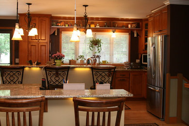 Eat-in kitchen - traditional eat-in kitchen idea in Minneapolis with an undermount sink, raised-panel cabinets, medium tone wood cabinets, granite countertops and stainless steel appliances