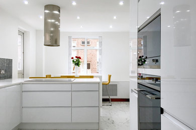 Design ideas for a large modern grey and cream u-shaped kitchen/diner in London with a built-in sink, flat-panel cabinets, white cabinets, onyx worktops, grey splashback, glass sheet splashback, stainless steel appliances, marble flooring and a breakfast bar.