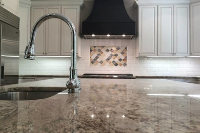 Inspiration for a large timeless kitchen remodel in Atlanta with white backsplash, ceramic backsplash, stainless steel appliances and an island